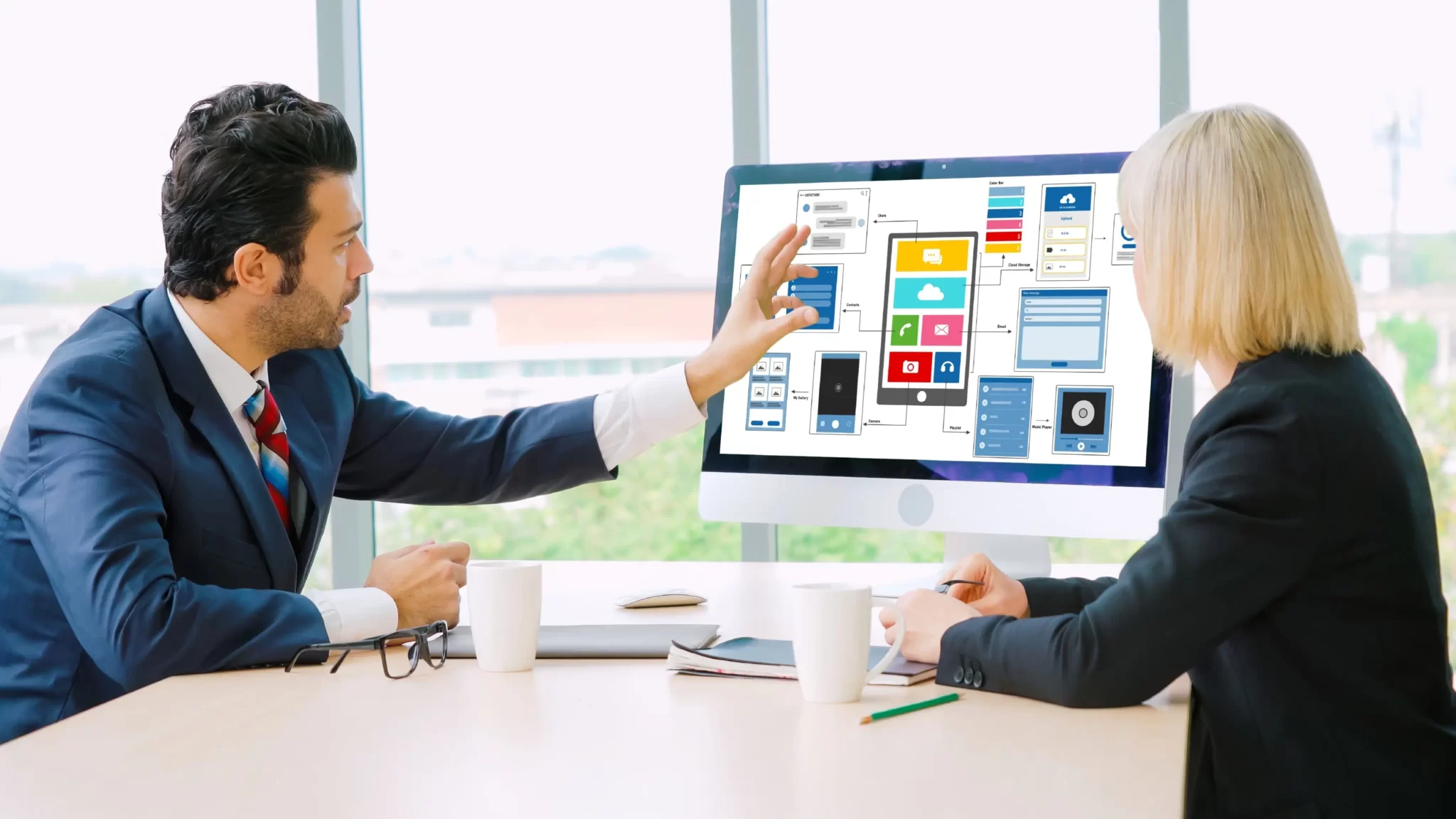 Designers reviewing a website UI wireframe on a desktop screen